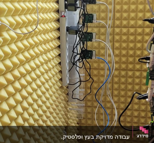 חדר עם קירות אקוסטיים, כבלים וציוד אלקטרוני